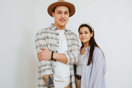 A tall man and a short woman against a gray wall.の写真素材