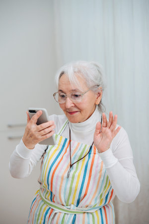 Elderly gray-haired woman talking to relatives on the phone. High quality photo