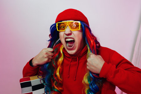 Expressive bizzare emotional man in silly colorful outfit shouting out of loud. He is wearing...