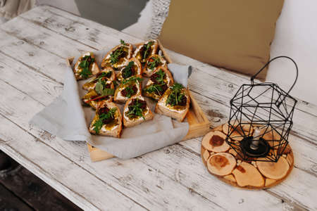 Delicious bruschetta toasts on a tray on a wooden painted bench outdoorsの写真素材