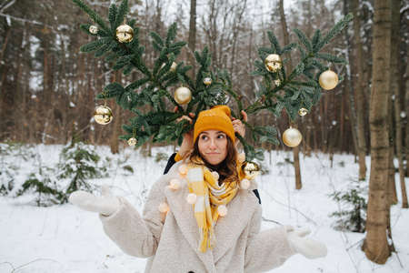 Winter holiday. A husband makes horns of Christmas tree for his wifeの写真素材