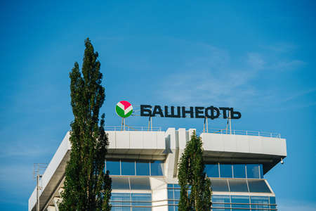 UFA, RUSSIA - JULY 21, 2021. Bashneft-polus main building against blue sky. Couple of trees in the foreground.のeditorial素材