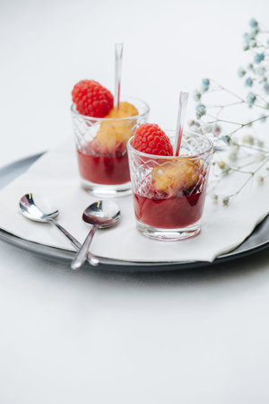 Dessert of grilled rice with raspberries and jam beautifully plated over white background. Lime and...