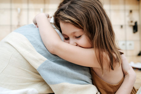 Sweet little girl hugging her parent. Blurred background