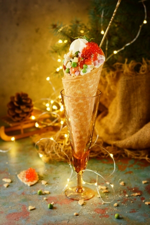 Olivier salad with red caviar in a waffle cup on a New Year's background. Custom feed, table dish.の写真素材