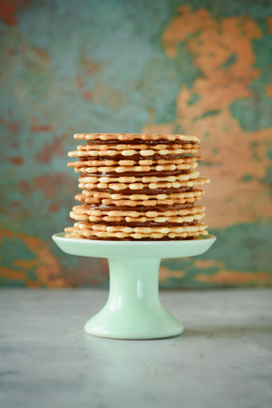 A stack of Dutch waffles with salted caramel on a gray background. Sweet waffle dessert.