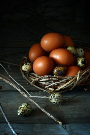 Colored Easter eggs in a wooden basket on a white background. Happy easter. Easter decoration.の写真素材