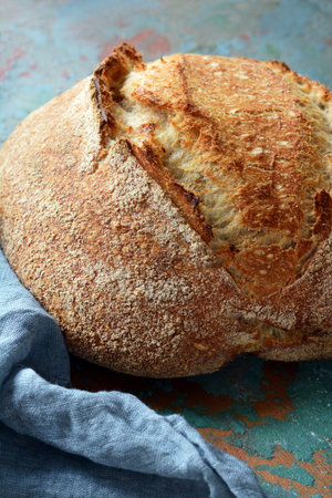 Fresh homemade bread on a gray-blue background, on whole wheat flour. French bread round shape....