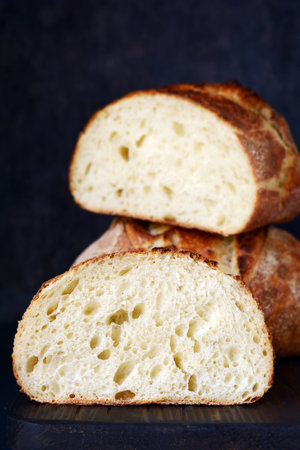 Fresh homemade bread on a dark background, on whole wheat flour. French bread round shape. Bread...