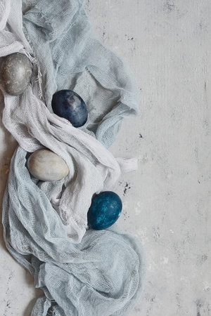 Dyed Easter vintage eggs with scuffs on a light gray background. Stylish Background with easter...