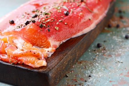 Gravlax, scandinavian beet cured spiced salmon on the board, top view, salted red fishの写真素材