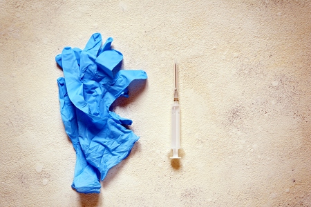 Blue medical gloves and a pair of textured background. Vaccination items, shots, Copy spaceの写真素材
