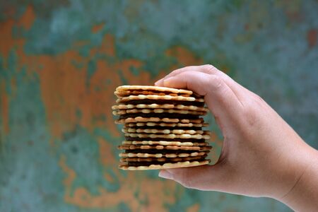 A stack of Dutch waffles with salted caramel on a gray background. Sweet waffle dessert. Belgian waffles, stack in handsの写真素材