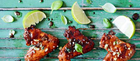 Hot buffalo chicken wings with soy sauce dressing of green onions and lime. Appetizing bar snack. American traditional dish. BBQの写真素材