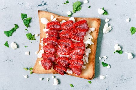 Toast with fruit raspberry, mint and cottage cheese for breakfast. Healthy breakfast, Ruddy bread toast. Traditional American and European summer breakfast: sandwiches of toast berry.の写真素材