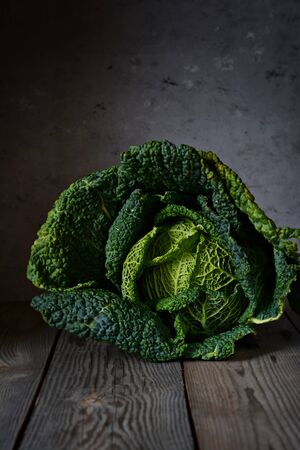 Green savoy cabbage on a dark background closeup. Healthy vegetable.の写真素材
