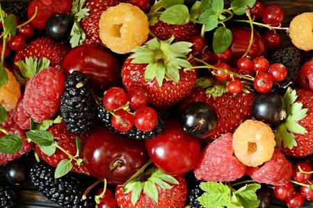 Summer berries on a wooden board close-up. Berry fruits like strawberries, blueberries, red currants, raspberries and blackberries on a wooden board.の写真素材