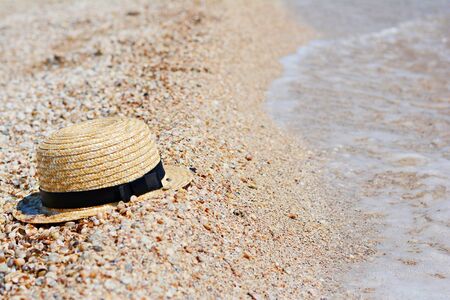 Straw hat on sand, sun protection concept. Women's beach accessories or summer outfit on a sandy background.の写真素材
