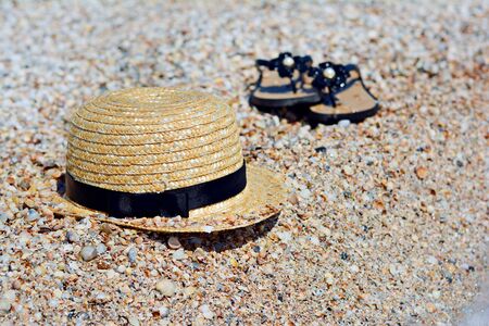 Summer vacation at sea. Hat and flip flops on a sand beach. Sun hat and sandals on beach. Selective focus. summer holidays concept.の写真素材