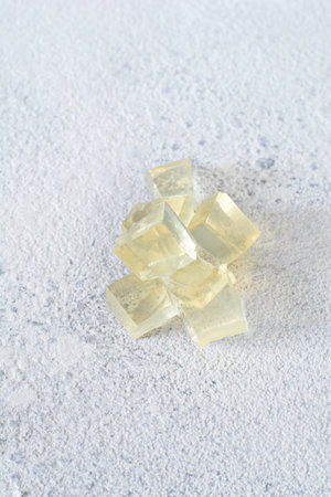 Gelatin, agar-agar, gelatinous mass (cubes in the form of crystals) on a gray background. Gelling...