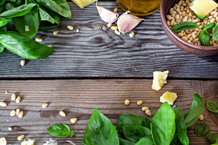 Layout of products for pesto sauce (Green pesto) on a wooden background, Flatlay. Basil leaves, nuts, cheese, garlic for making pesto sauce. Popular Italian dressing for salads, pasta and pizza.の写真素材