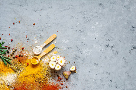 Various spice powders (paprika, curry, coriander, ginger, dried onions and garlic, turmeric, cinnamon, pepper, anise) and herbs (rosemary, bay leaf) on gray background. Indian and Asian cuisine.の写真素材
