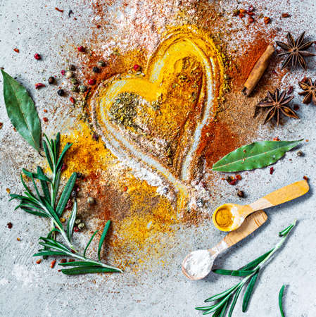 Various spice powders (paprika, curry, coriander, ginger, dried onions and garlic, turmeric, cinnamon, pepper, anise) and herbs on gray background. Indian and Asian cuisine. Love for spicesの写真素材