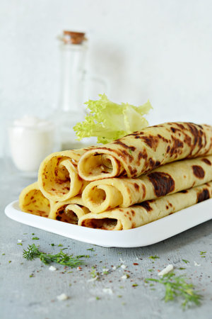 Norwegian potato pancakes Lefse on a light background with cheese and greens. Traditional Scandinavian cuisine.の写真素材