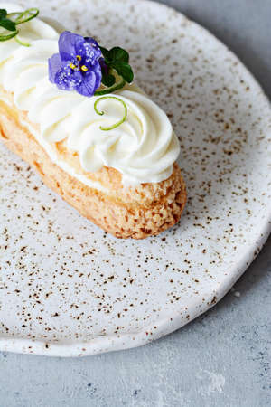 French eclair with fruit and chocolate coconut and gentle mousse. Delicious dessert. Cake in the glaze. Confectionery product.の写真素材