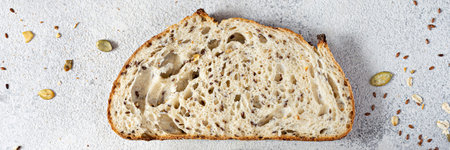 Fresh homemade bread (slice) from whole grain sourdough flour with the addition of bran, seeds...