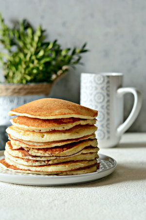 Sweet Homemade Stack of Pancakes with honey for Breakfast on a gray background. Brunch.