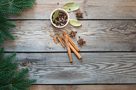 Traditional Christmas spices for cooking and drink (mulled wine) on a wooden background with fir...