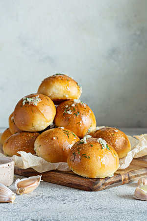 Freshly baked buns (pampushki) with garlic and dill for the first course (soup) on a wooden board. National Ukrainian dish, food. selective focus.の写真素材
