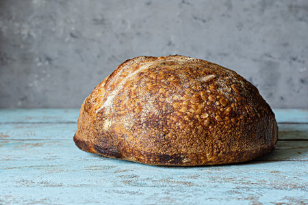 Fresh homemade sourdough bread with whole grain flour on a gray-blue background. Health food.