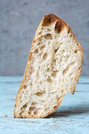 Fresh homemade sourdough bread with whole grain flour on a gray-blue background. Health food.