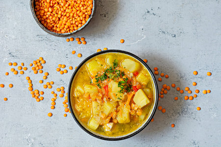 Soup with red lentils and vegetables in a bowl on a blue background.Traditional dish of Turkish or...
