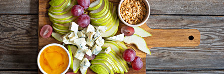 Sliced Blue cheese, dor blue or roquefort and fruits (grapes, pears), nuts and honey on a board. Exquisite appetizer for wine. fruity cheese plate.の写真素材