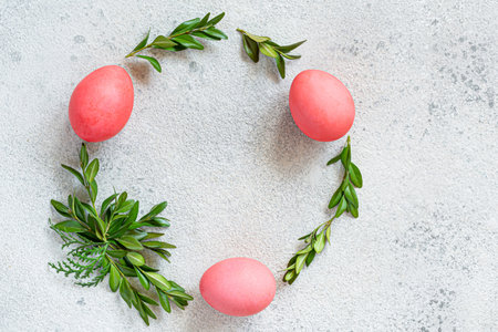 Easter wreath of pine needles, boxwood and painted eggs on light background. Festive concept, top view, copyspace.の写真素材