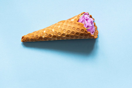 Wafer cone with tulips on a blue background. Flower ice cream, spring concept with first flowers.の写真素材