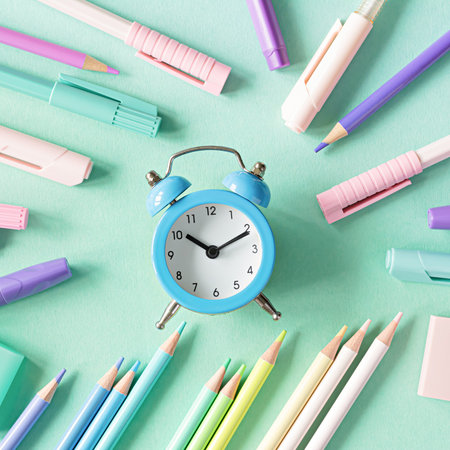 Back to school, education and work concept. Stationery for learning (study) and alarm clock on mint background. View from above, top view. Wake up time.の写真素材