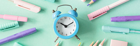 Back to school, education and work concept. Stationery for learning (study) and alarm clock on mint background. View from above, top view. Wake up time.の写真素材