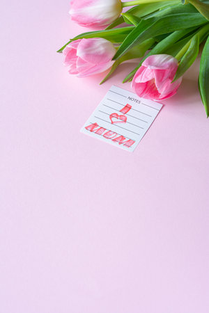 Bouquet of pink tulips on pink background. Greeting card for mother's day, women's day March 8. Celebration of spring holidays. Flat lay from flowers, top view, copy space.の写真素材