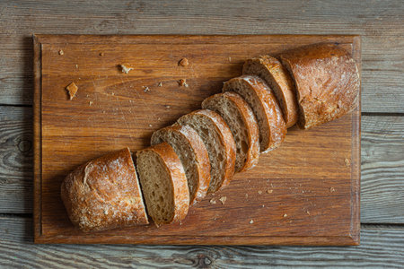 Fresh baked buckwheat (whole grain) bread, on a wooden background. Crispy baguette with a delicate...