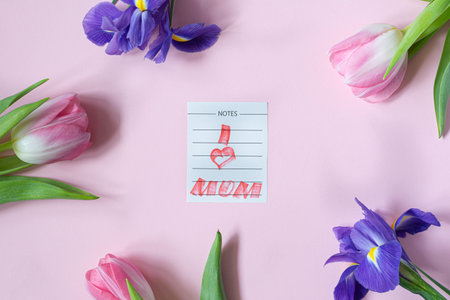 Bouquet of pink tulips and irises on pink background. Greeting card for mother's day, women's day....