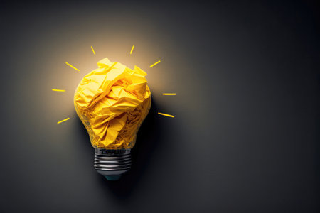 concept of a great idea, featuring a crumpled yellow paper light bulb isolated on a dark background. The light bulb is a universal symbol for creativity and innovation, and the crumpled paper suggests that this idea is in the process of being formed and refined. The dark background creates a sense of mystery and intrigue, emphasizing the potential for breakthrough ideas to emerge from unexpected places.の写真素材