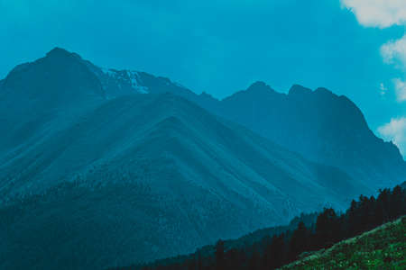 high cliffs in blue haze, silhouette of mountain range in fog, meditation and relaxation in nature
