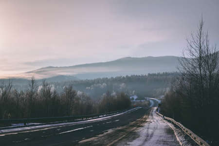 Icy cold winter road in the morning fog