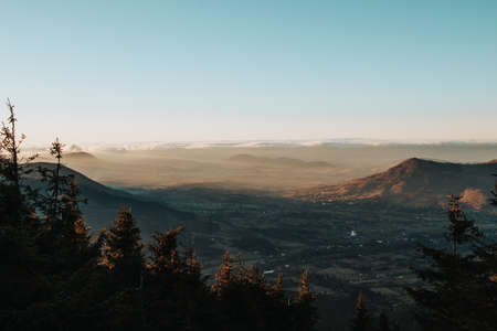 Approaching storm clouds with intersecting sunset and valley view in Beskydy mountains, Czech Republic, Europe. Aerial view to sunbeams falling on mountains and valleys.