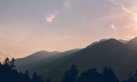 Alps mountain silhouette with trees and sunset sky. Austria landscape