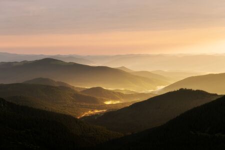 Morning fog in spring mountains. Beautiful sunrise on background. Landscape photography